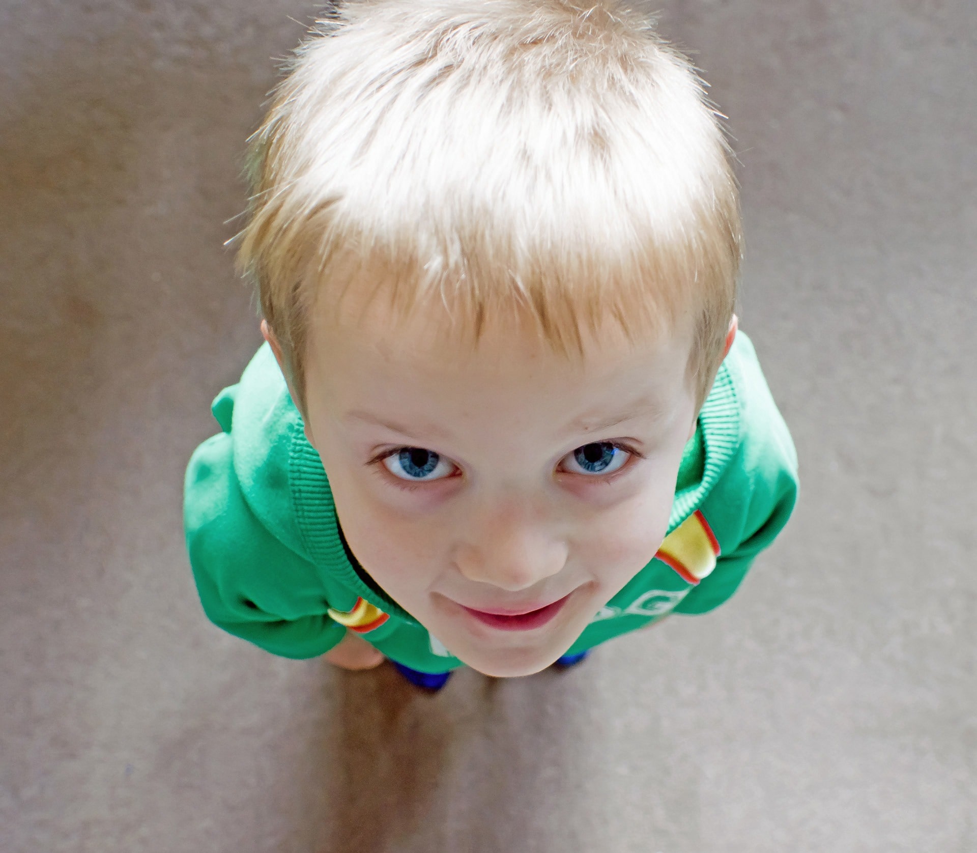 chłopczyk z niebieskimi oczami patrzy w górę