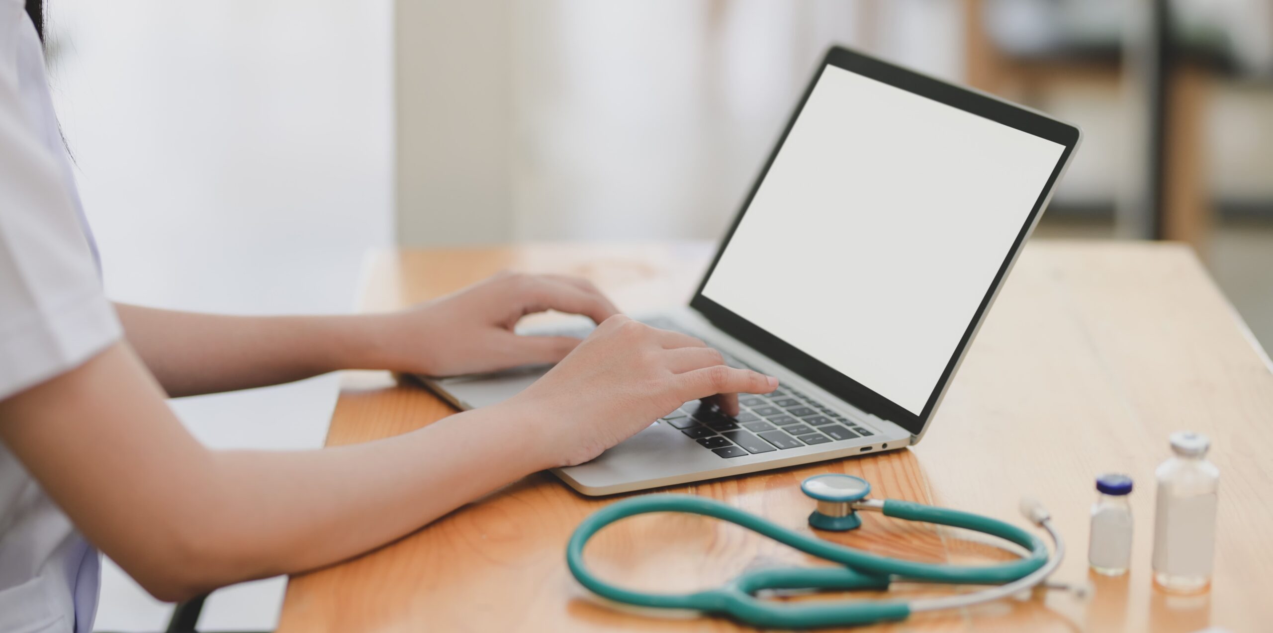 lekarz piszący na laptopie