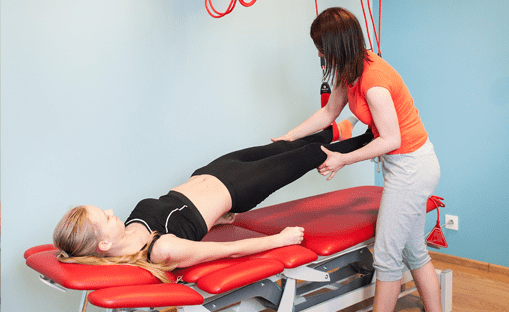 fizjoterapeuta rehabilituje dziewczynkę na łóżku fizjoterapeutycznym metodą neurac