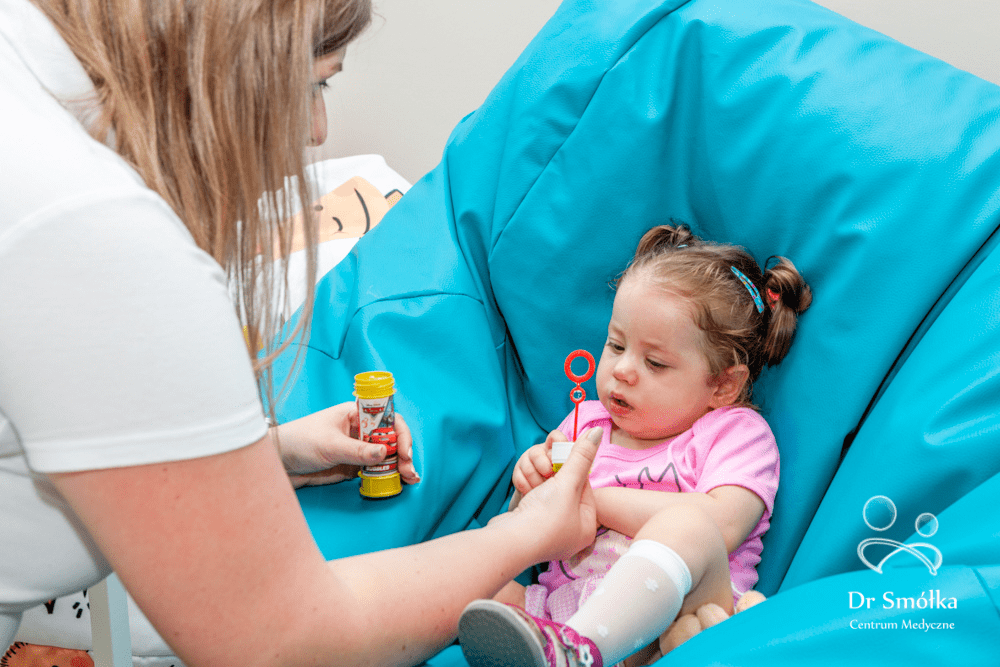 fizjoterapeuta podczas terapii dziecka z mózgowym porażeniem dziecięcym