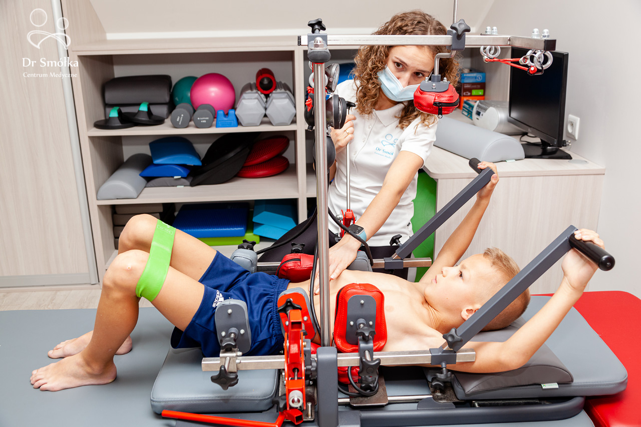 fizjoterapeuta i dziecko podczas rehabilitacji skoliozy przy pomocy urządzenia SKOL AS