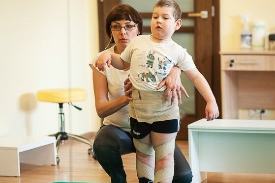 dziecko ćwiczy ze specjalistą na turnusie rehabilitacyjnym w Centrum Medycznym Dr Smółka