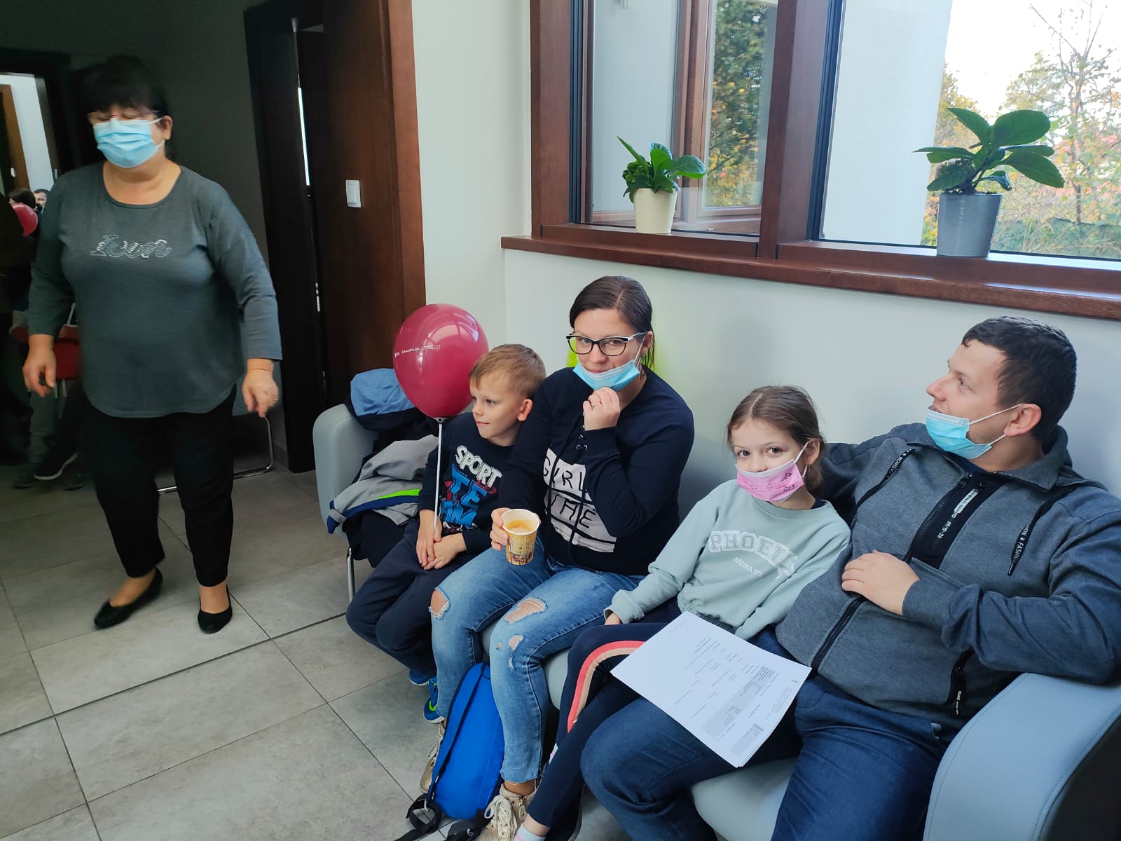 rodzice w maseczkach siedzą z dziećmi na poczekalni w Centrum Medycznym Dr Smółka